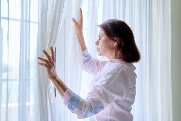 istock Sad serious mature woman looking out the window 1391749178