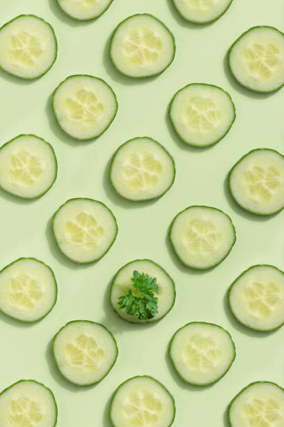 istock Cucumber slices on a green background 1391750027