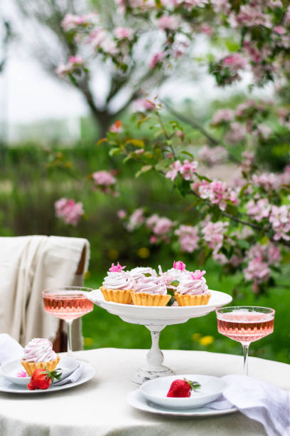 istock Festive spring romantic table setting with dessert in blossom garden. Vertical 1391751107