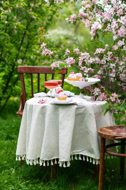 istock Festive spring romantic table setting with dessert in blossom garden. Romantic table concept. Vertical. 1391751608