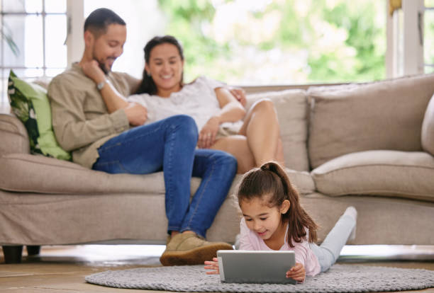 istock Shot of a little girl using a digital tablet while relaxing at home 1391753061