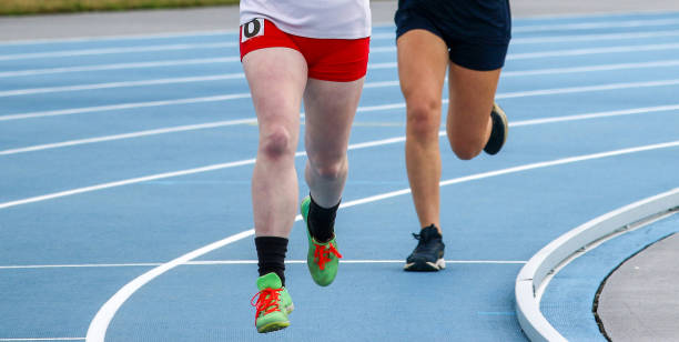 istock Two young girls running a race on a blue track 1391755175