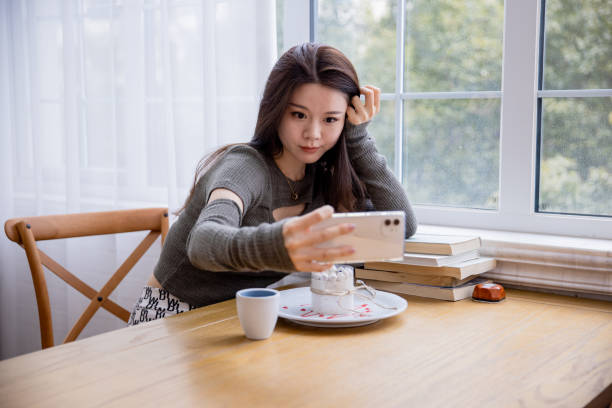 istock Young women talking a selfie with phone at a cafe 1391759212