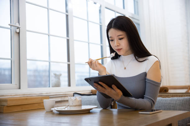 istock Women using tablet and eating a cake at cafe 1391759499