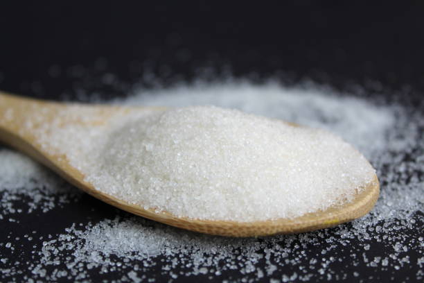 istock A wooden spoon with sugar lies on a black background. 1391761447