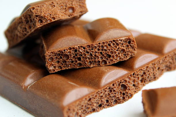Aerated milk chocolate lies on a white background.