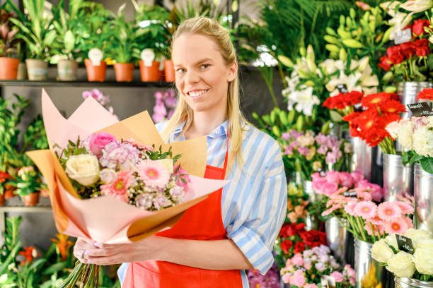 istock Flower shop worker holding a flower arrangement 1391762063