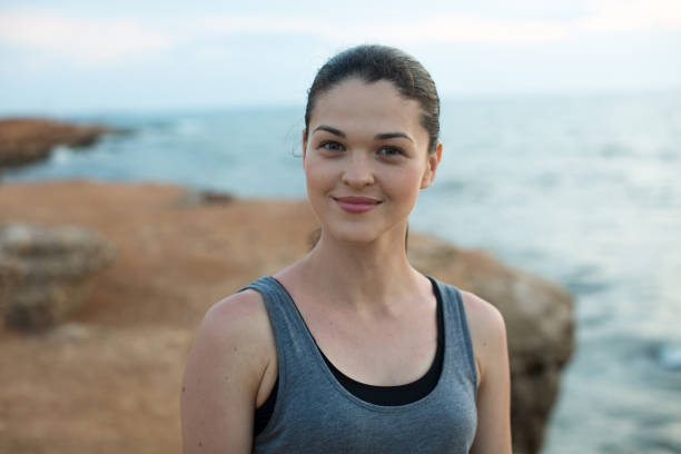 istock Smiling female jogger on the sea at sunset. 1391762185