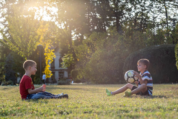 istock Two boys playing with ball in the park 1391762292