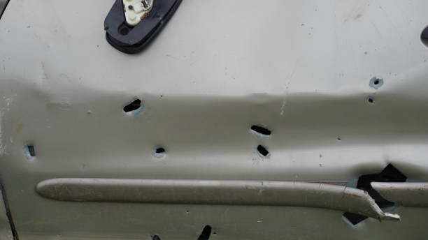 Automobile shot up shrapnel bullet shot cracked hole on car surface