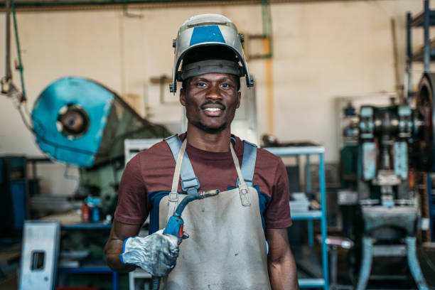 Afro American welder welding automatic welding torch stock pictures, royalty-free photos & images