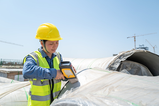 A female engineer who used a hand-held spectrometer to measure materials on the construction site