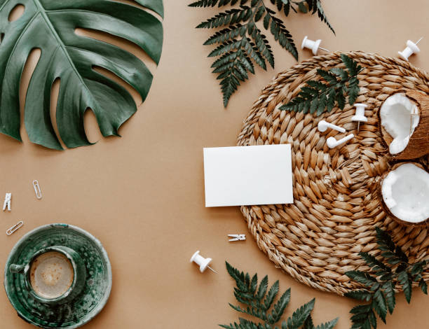istock Mock up blank card, flat lay with coffee cup, coconut, green monstera leaf on brown background. Space for text, blogger background, neutral colors, workspace 1391768643