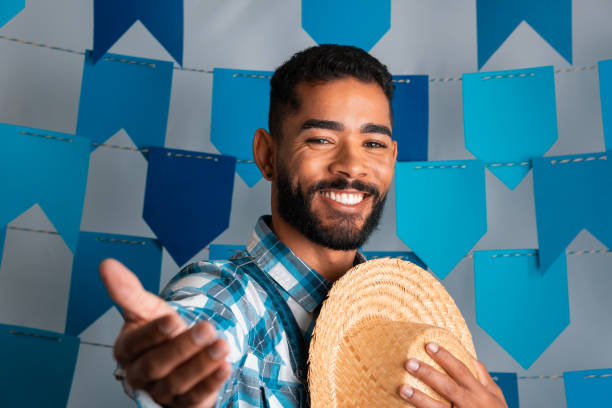 June Festival, cheerful man inviting to Festa Junina Brazilian June Festival, cheerful man inviting to Festa Junina in Brazil in caipira clothes june 1 stock pictures, royalty-free photos & images