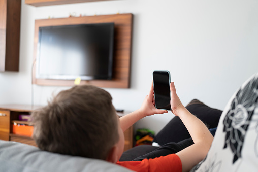 Child using smart phone at home.