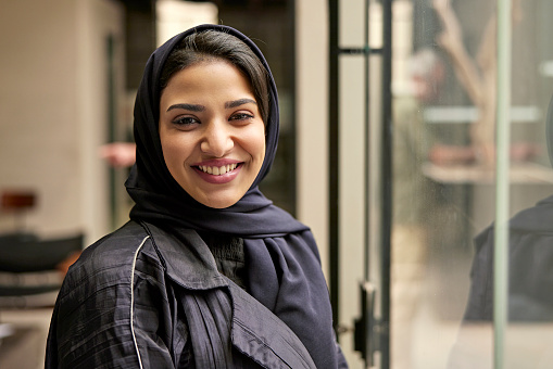 Indoor portrait of cheerful Saudi woman in mid 20s