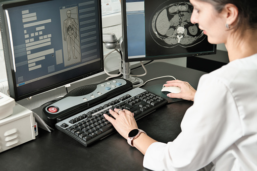 middle east woman doctor looking at monitor with computer tomography image. female young radiologist examining ct test results