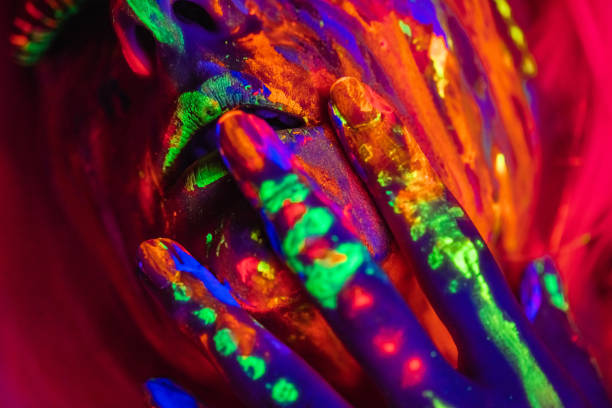 Portrait of a beautiful young woman wearing fluorescent makeup. Close-up.