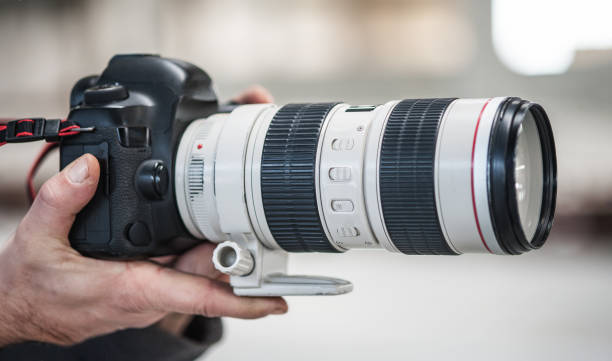 istock Photographer and videographer holding camera, take photo or record video 1391776676