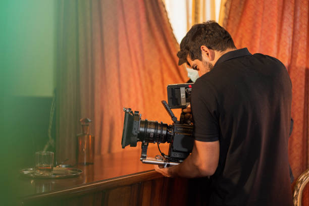 Video camera in film or movie production on tripod and professional gear which shooting in location or studio with crew team and beautiful prop or set and ready to online live broadcast or tv on air later cámara de video en la producción de películas o películas en trípode y equipo profesional que filma en el lugar o estudio con el equipo de equipo y un hermoso accesorio o set y listo para la transmisión en vivo en línea o la televisión en el aire m