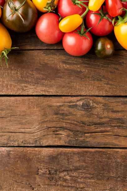 istock Overhead shot of mixed tomatoes on rustic wooden background with copyspace. Top view 1391783465