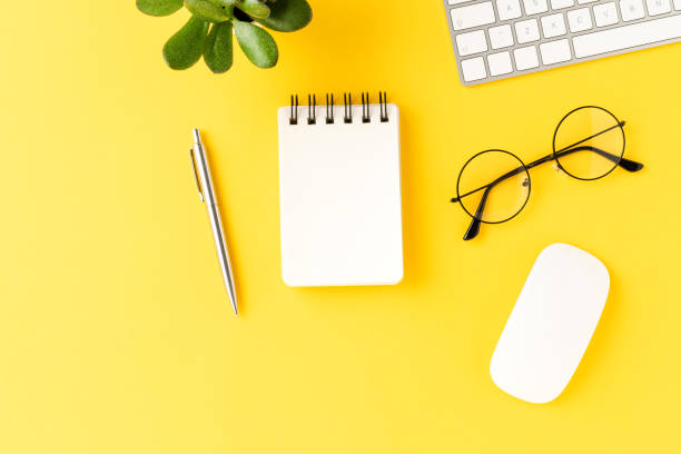 istock Business background with empty notebook on yellow table. Office desktop with accessories 1391783743