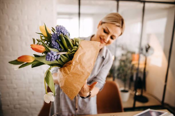 istock Young woman arranging tulips at home 1391783982