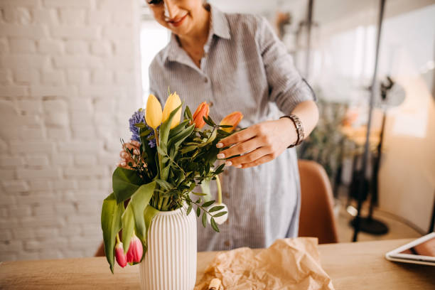 istock Young woman arranging tulips at home 1391784045