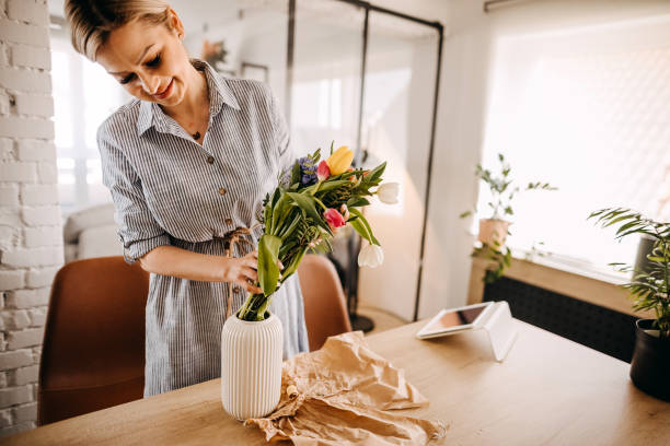 istock Young woman arranging tulips at home 1391784046