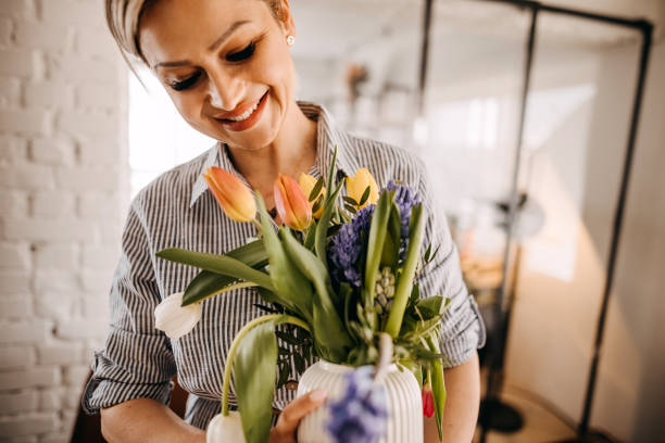 istock Young woman arranging tulips at home 1391784072