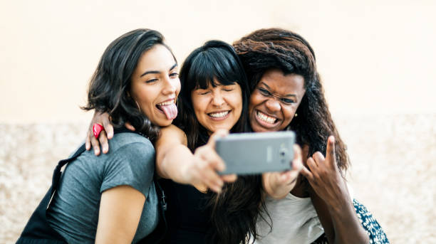 istock Three young woman friends taking a selfie 1391784340