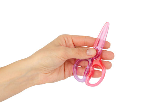 istock Pink scissors in the hand, white background 1391790315