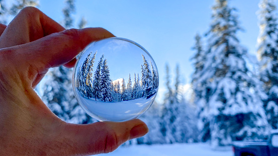 The beauty of a winter scene is reflected in a crystal ball. Alaska’s winter snow makes for stunning photo opportunities.