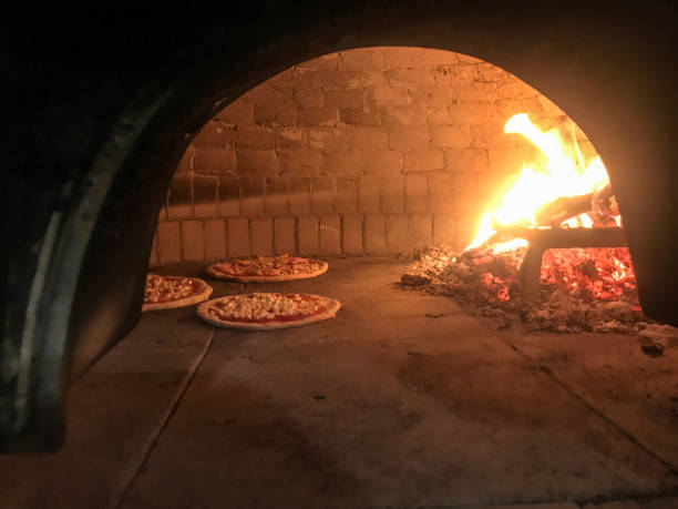 istock Wood oven with pizza being cooked 1391792187