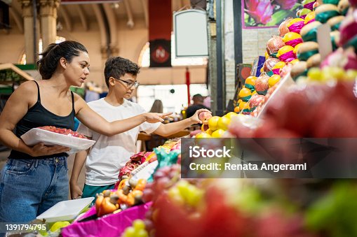 istock Mother and son buying fruits at the municipal market 1391794795