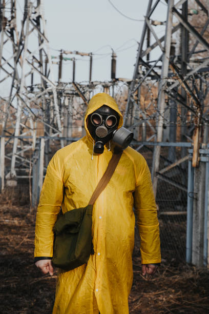 istock male worker standing on territory of power station. Environmentalist wearing protective uniform, gas mask. 1391794952