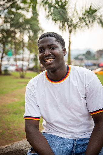 Portrait of a smiling young African man, happy young adult outside.