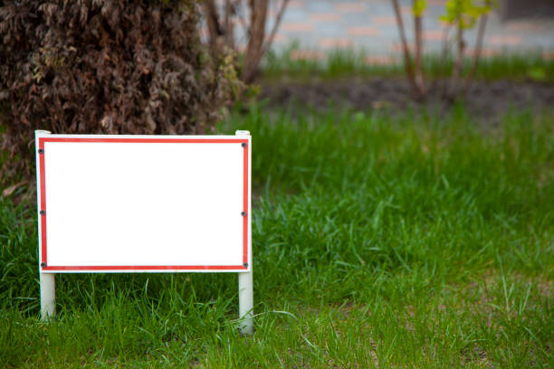 Pointer sign on the lawn with green grass. Banner layout with place for the text dog walking is prohibited , do not walk on the lawn, it is dangerous. Information board layout. Mockup Pointer sign on the lawn with green grass. Banner layout with place for the text dog walking is prohibited , do not walk on the lawn, it is dangerous. Information board layout. Mockup. yard sign stock pictures, royalty-free photos & images