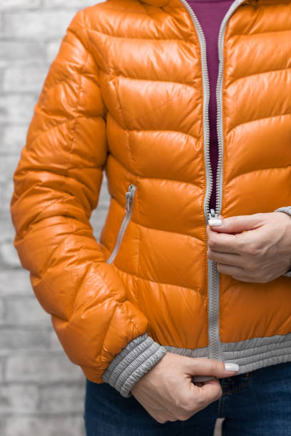 istock girl zips up her bright down jacket 1391804331