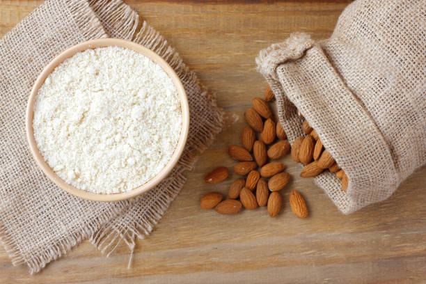 organic raw almond flour in bowl over rustic wooden table stock photo