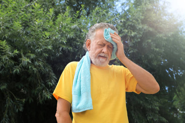 屋外で熱中症に苦しむタオルを持った先輩男性 - senior male ス�トックフォトと画像