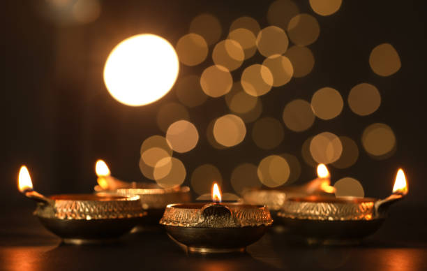 istock Lit diya lamps on dark table. Diwali celebration 1391811053