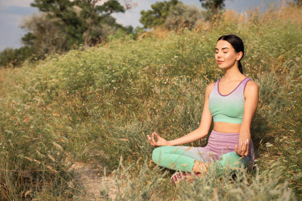 istock Young woman meditating on hill. Space for text 1391811305