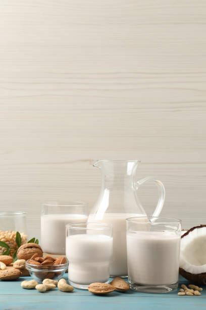 istock Different nut milks on light blue wooden table. Space for text 1391812404