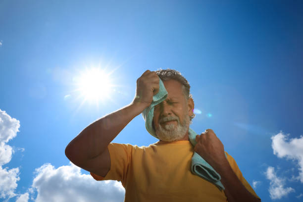 Senior man with towel suffering from heat stroke outdoors, low angle view Senior man with towel suffering from heat stroke outdoors, low angle view dehydration stock pictures, royalty-free photos & images