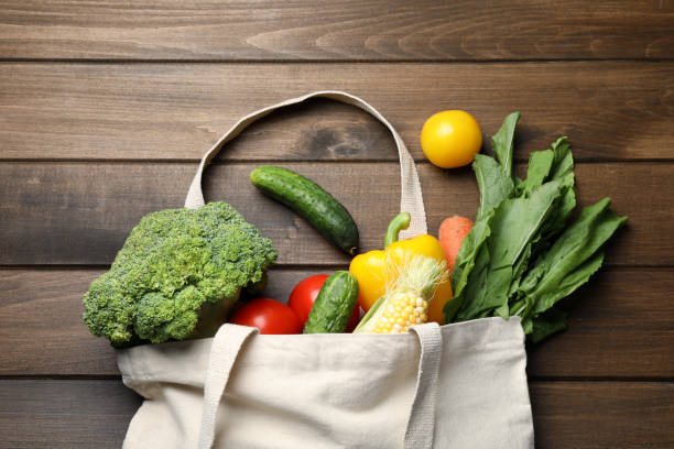 istock Cloth bag with different vegetables on wooden table, flat lay 1391813617