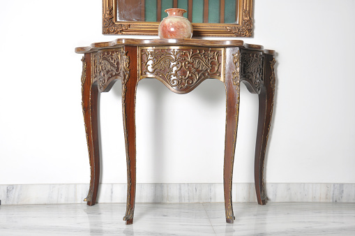 Carved table placed with wall and a Ceramic pot over it in Balcony.