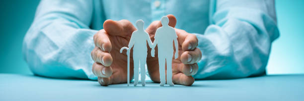 Hand Protecting Senior Couple Cutout Figures Hand Protecting Senior Couple Cutout Figures On Desk retirement stock pictures, royalty-free photos & images
