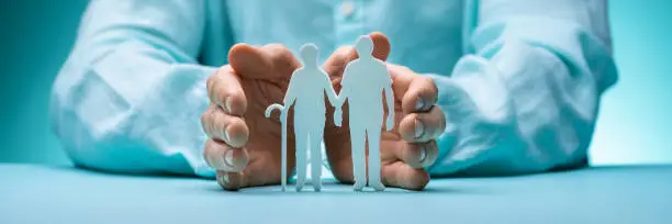 Photo of Hand Protecting Senior Couple Cutout Figures