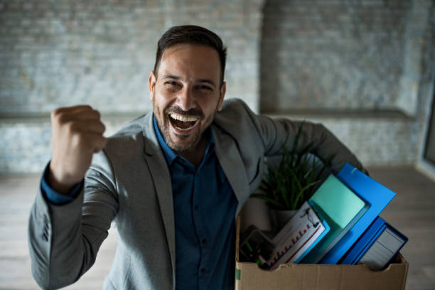 First day at office. Portrait of ecstatic young businessman with belongings moving to new office stock photo